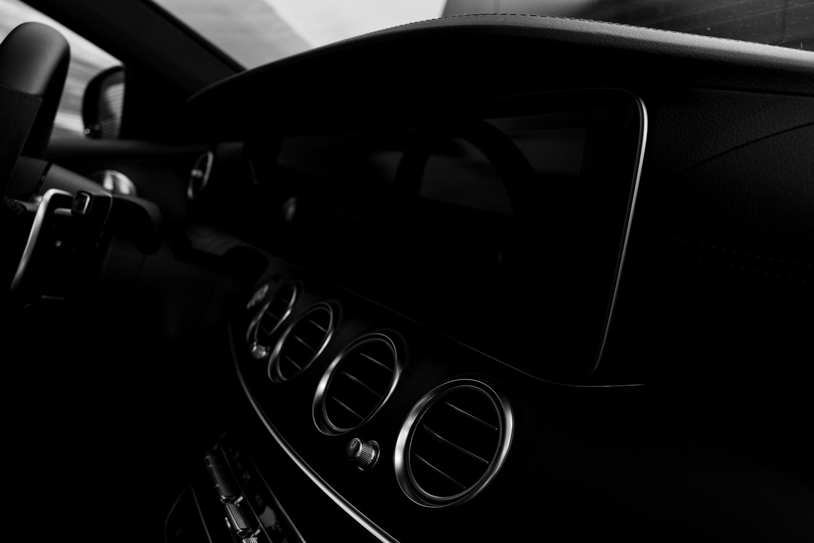 Detail brush cleaning the air vents of a car dashboard